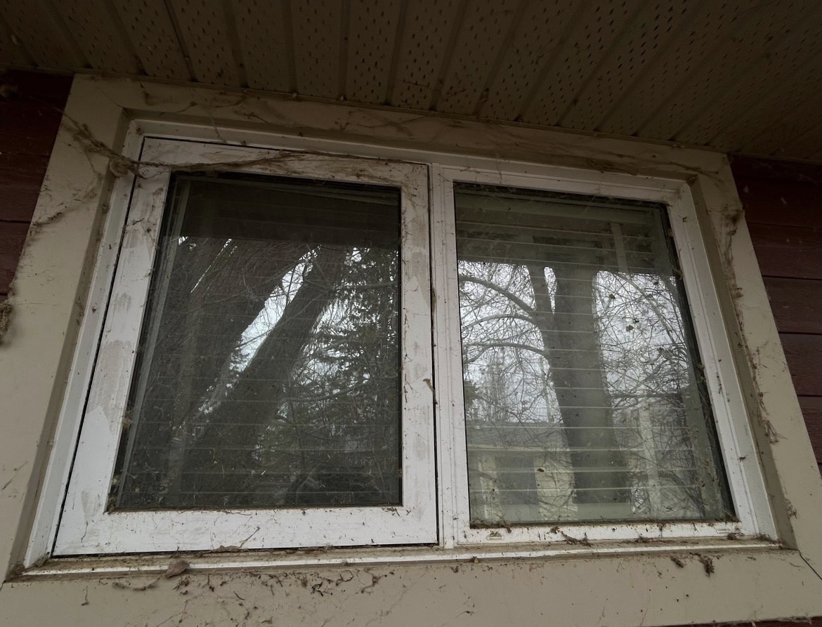 Window and frame covered in dirt and splatter before cleaning