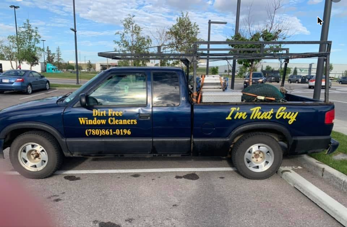 The navy Dirt Free Window Cleaners truck with gold lettering and ladder racks